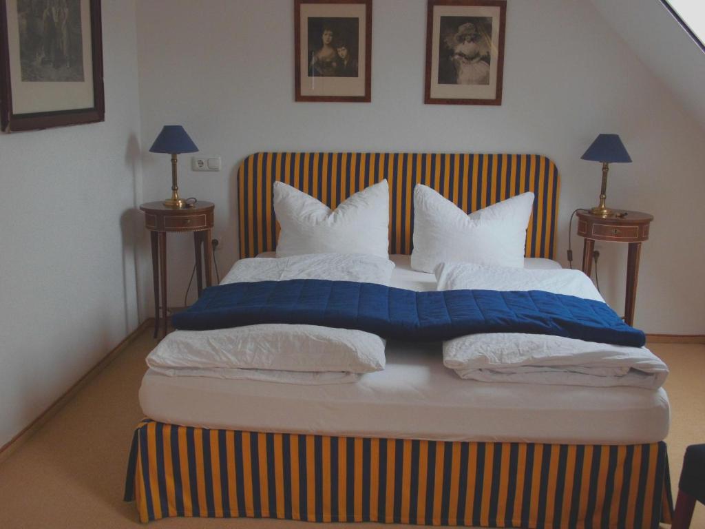 格吕克斯塔特Pension Am Museum的一间卧室配有一张带蓝白色枕头的大床