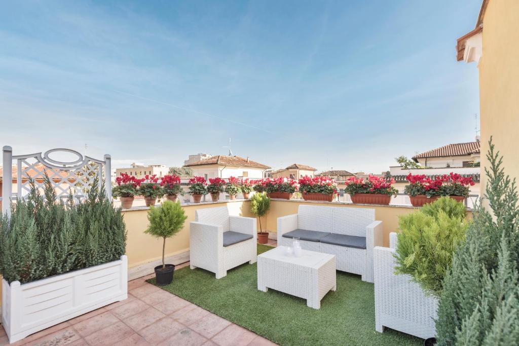 罗马Hotel Infinito - Gruppo BLAM HOTELS的屋顶庭院配有白色家具和植物