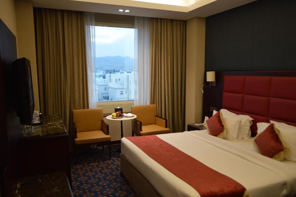 马斯喀特苎麻集团盖斯特林酒店的一间设有大床和窗户的酒店客房