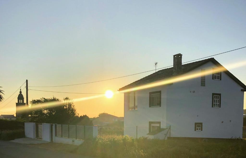 巴雷罗斯Barranca de San Miguel的白色的房子,后面有太阳