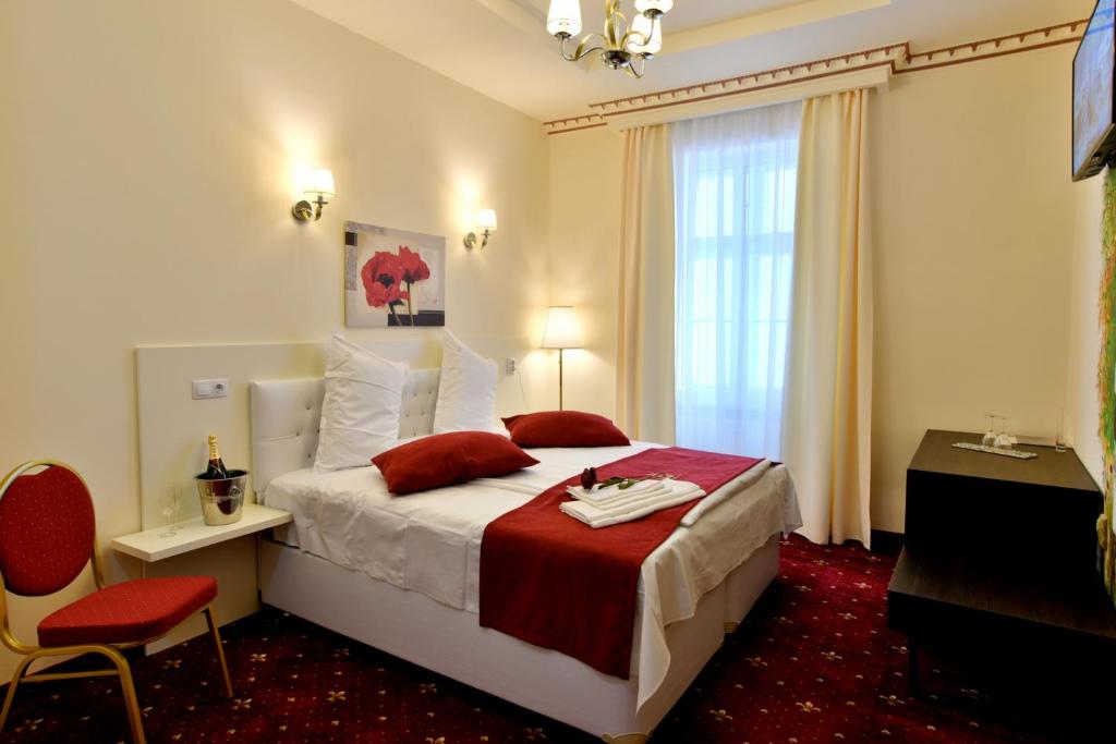 布拉索夫Top Royal Central Brasov的酒店客房,配有一张带红色毯子的床