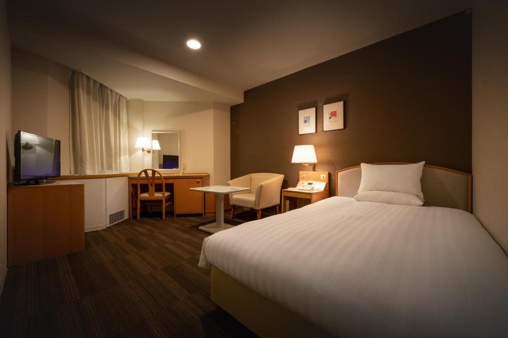 千岁机场航站楼酒店的酒店客房配有一张床、一张书桌和一台电视。