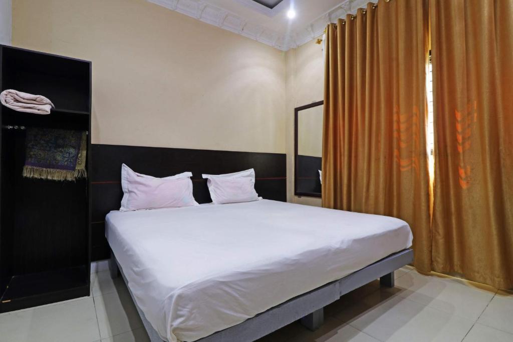 北干巴鲁Utama Syariah的一间卧室配有带白色床单和枕头的床。