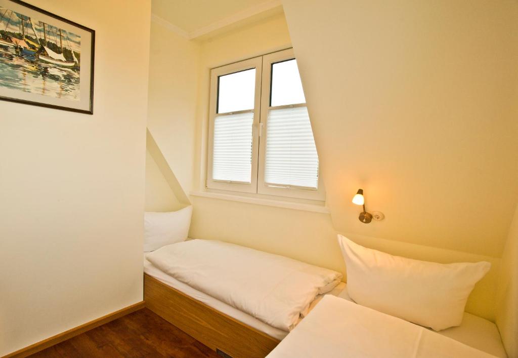 希登塞Ferienhäuser Südwind的小房间设有床和窗户
