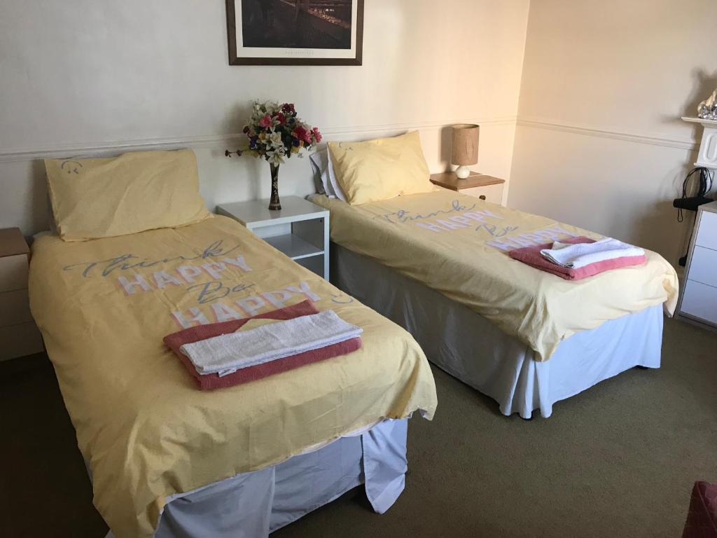 南安普敦Double J8 m27的配有毛巾和鲜花的客房内的两张床