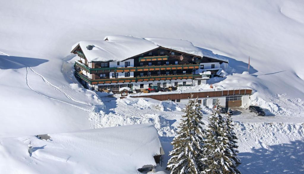 上柯尼希山麓米尔巴赫Alpengasthof-Hotel Kopphütte的一座白雪覆盖的山顶上的建筑