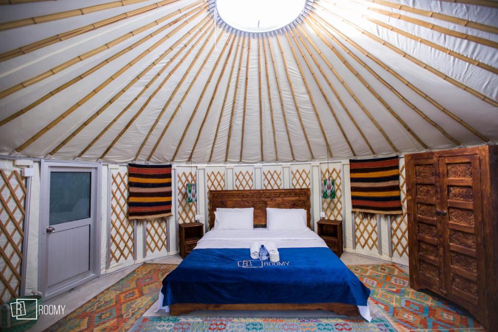 Roomy Yurts, Minapin Nagar Hunza的蒙古包内一间卧室,配有一张床