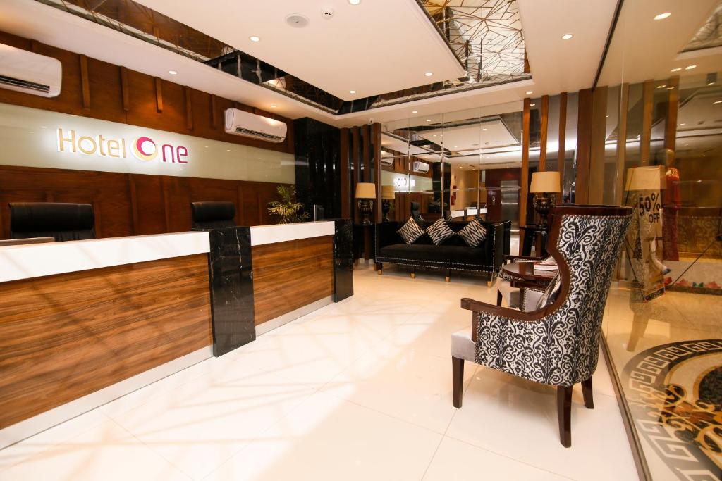 拉希迈尔汗Hotel One Rahim Yar Khan Club Road的酒店大堂设有椅子,酒店则设有一张