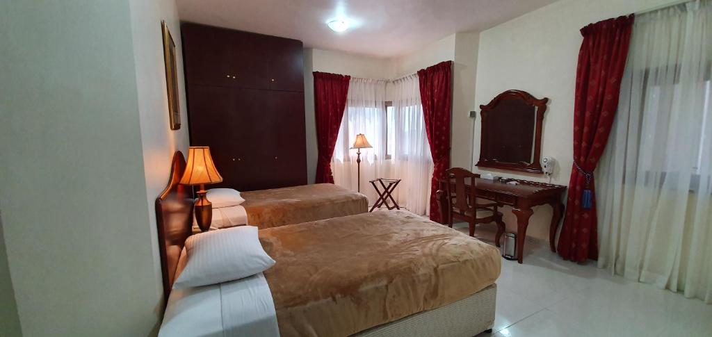 阿布扎比象牙酒店公寓的酒店客房配有两张床和一张书桌