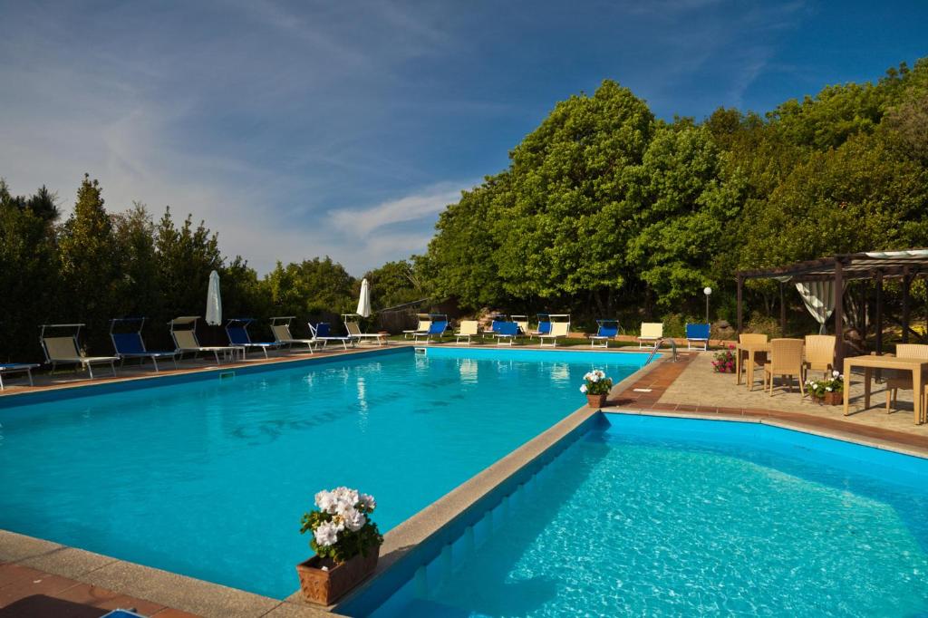 坦皮奥袍沙尼亚保萨尼亚酒店的一个带桌椅的大型蓝色游泳池