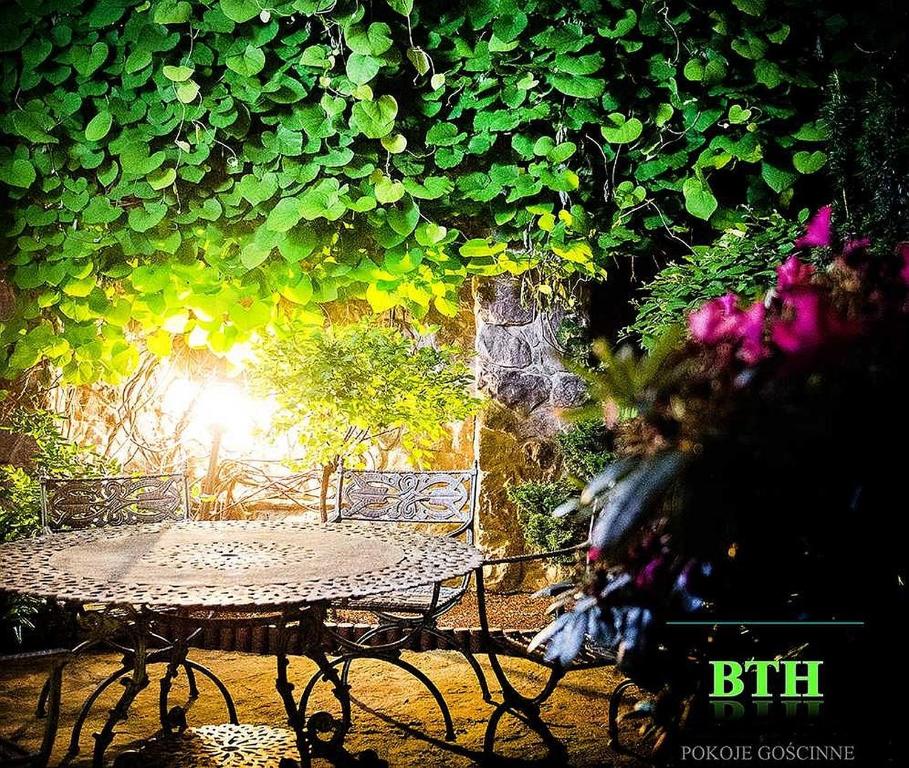 华沙BTHouse, Pokoje Gościnne的绿叶花园内的桌椅
