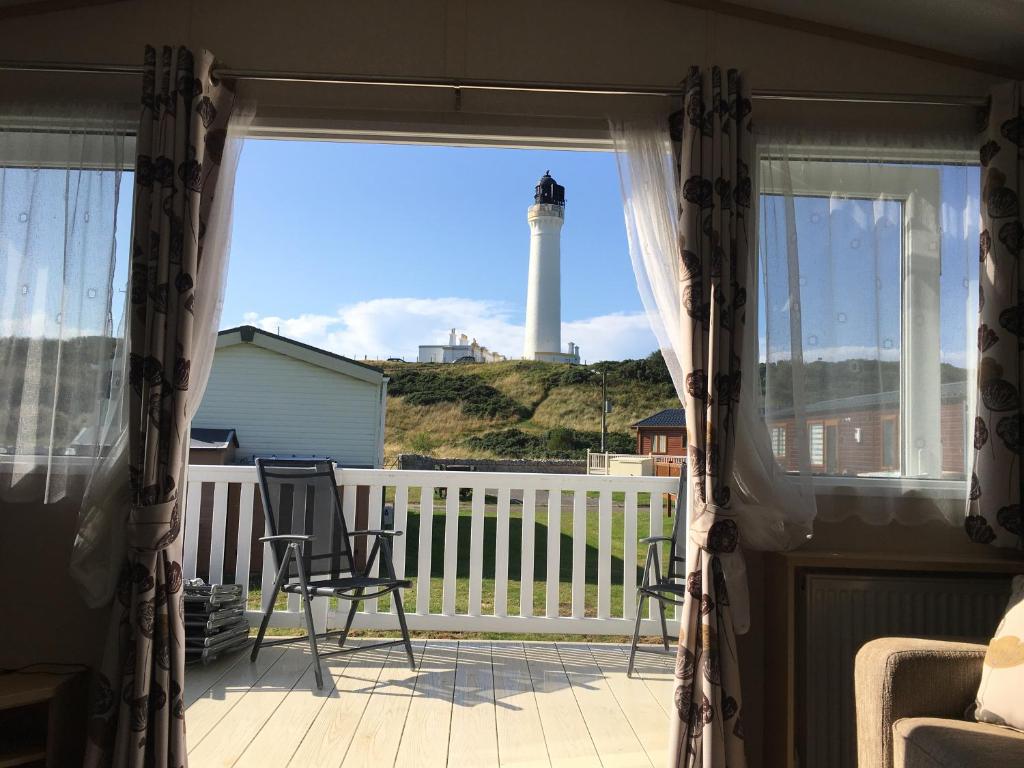 洛西茅斯87 Lighthouse View Lodge的从房子的门廊上可欣赏到灯塔的景色