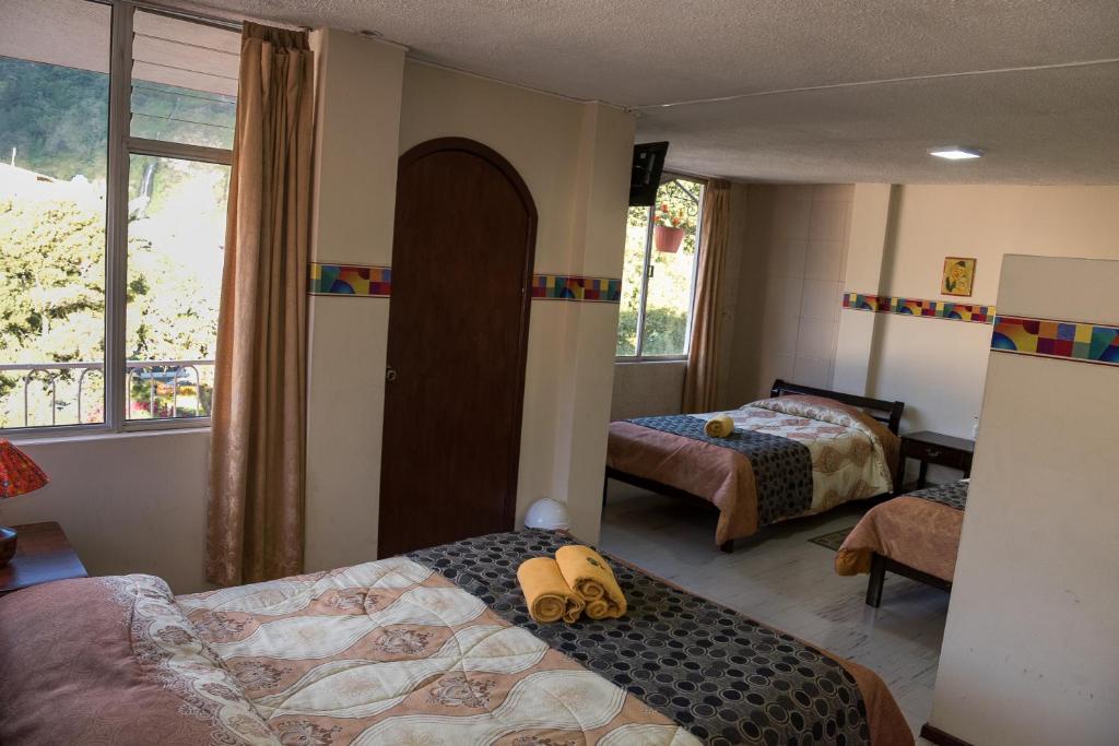 巴尼奥斯Hotel Flor de Oriente的一间卧室设有两张床和窗户。