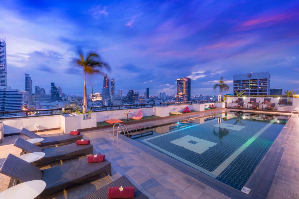 曼谷Furama Silom Hotel的一座城市天际线建筑的顶部游泳池