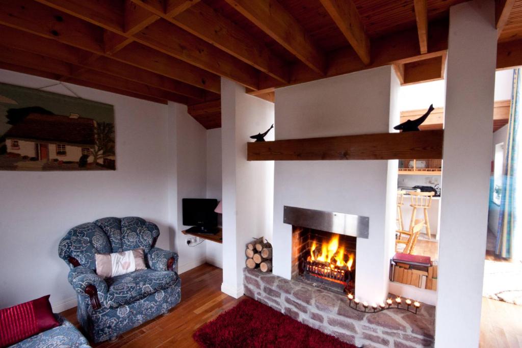 Achill Sound阿基尔度假屋的客厅设有壁炉和椅子