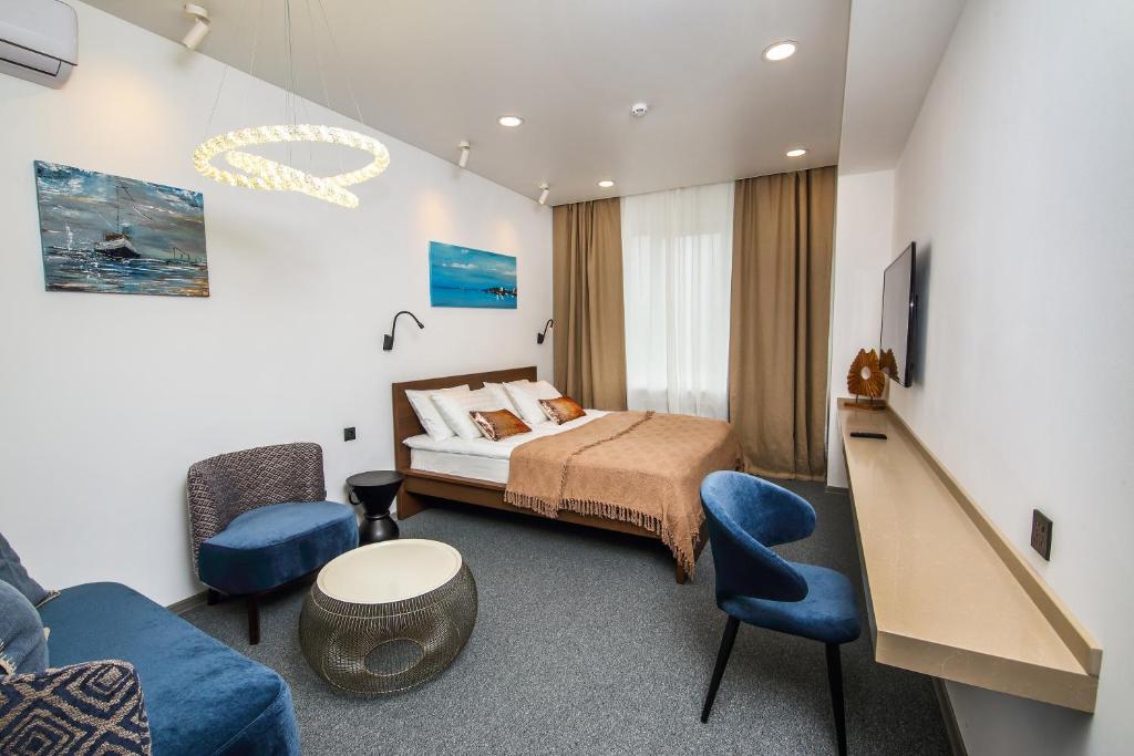 符拉迪沃斯托克SV Hotel的一间卧室配有一张床、一张沙发和一台电视。
