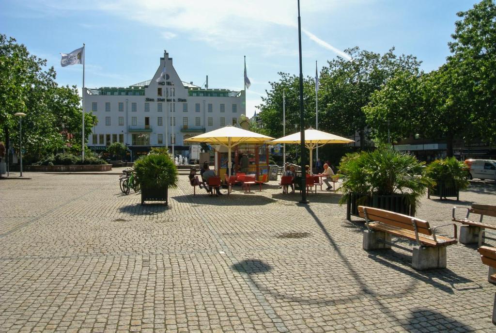 埃斯勒夫Hotel Stensson的一个带桌子和遮阳伞的庭院和一座建筑