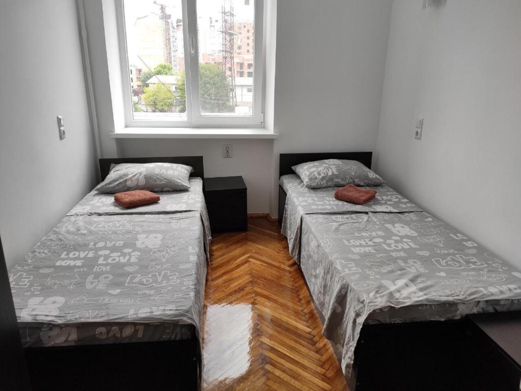 伊万诺-弗兰科夫斯克Дешеві кімнати біля парку的两张床位于带窗户的房间内