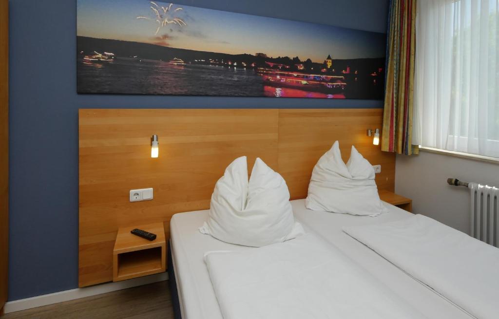 雷马根平格尔酒店的配有白色枕头的床的酒店客房
