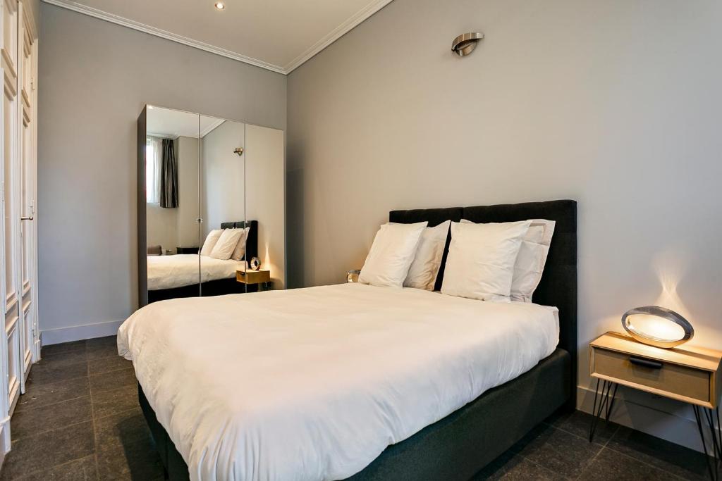布鲁塞尔Fish Market B&B的卧室配有一张白色大床和镜子