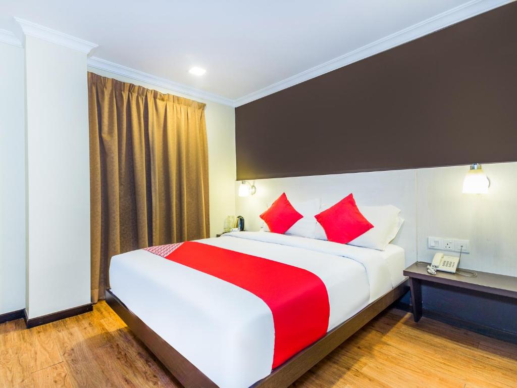 吉隆坡OYO 431 Hotel De Grand Orchard的酒店客房配有一张带红色枕头的大床
