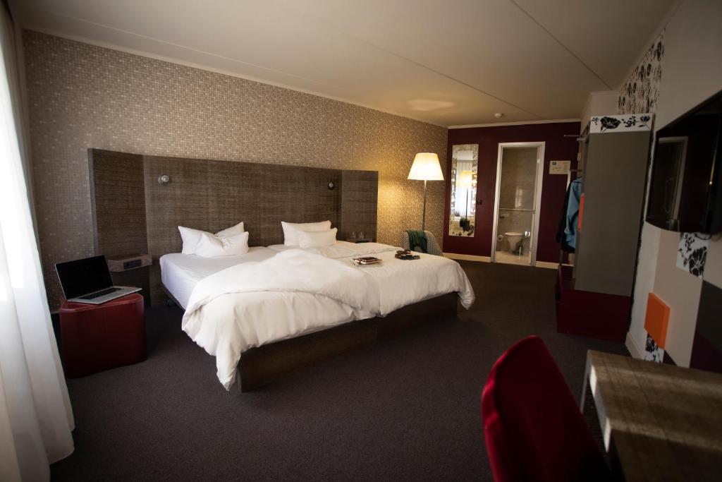 艾森纳赫pentahotel Eisenach的酒店客房带一张大床,带白色床单
