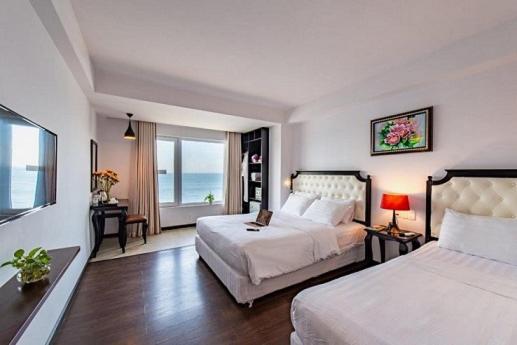 芽庄贝尔维尤酒店的一间带两张床的卧室,享有海景