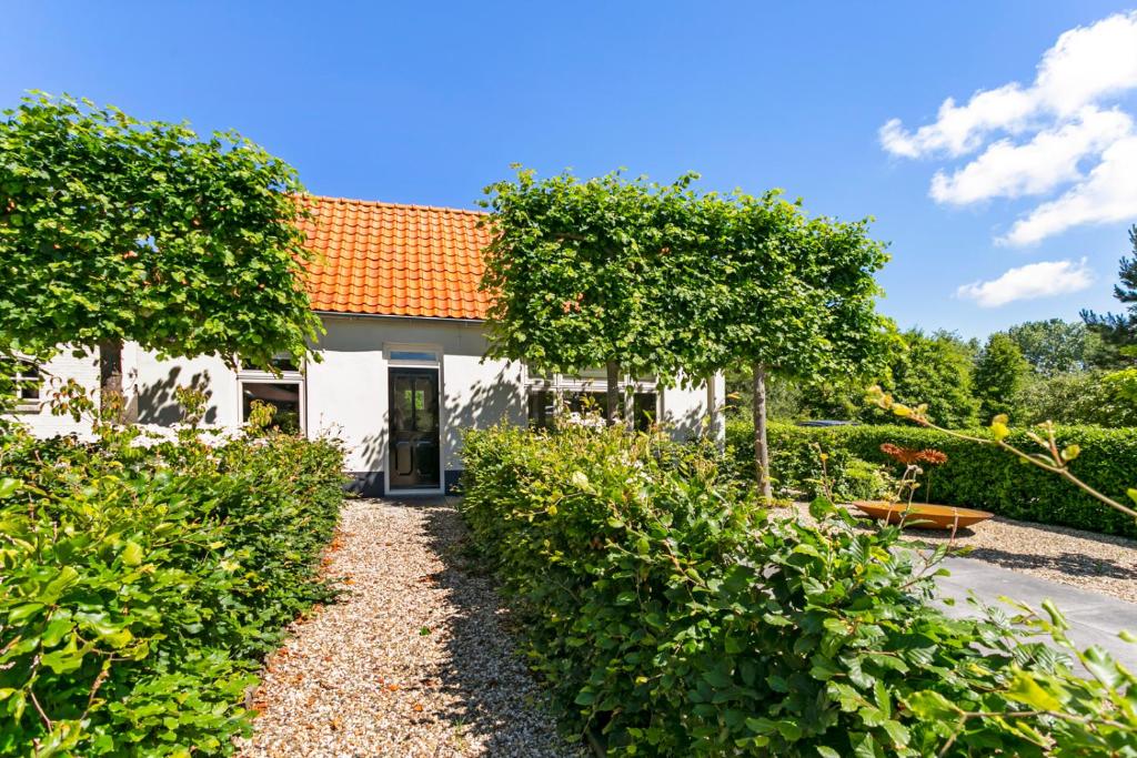 奥德多普Holiday home Dijkstelweg 30 - Ouddorp with terrace and very big garden, near the beach and dunes - not for companies的白色房子,有橙色屋顶