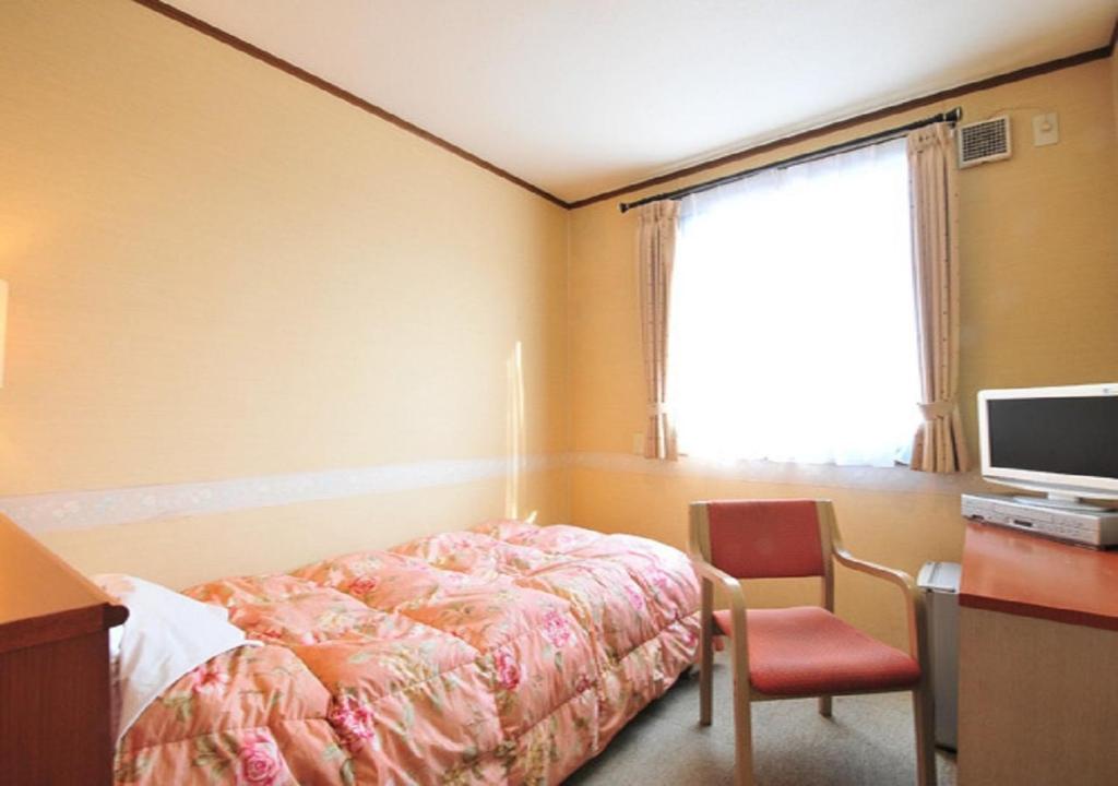 大村市Omura - Hotel / Vacation STAY 46222的一间卧室配有一张床、一张书桌和一台电视