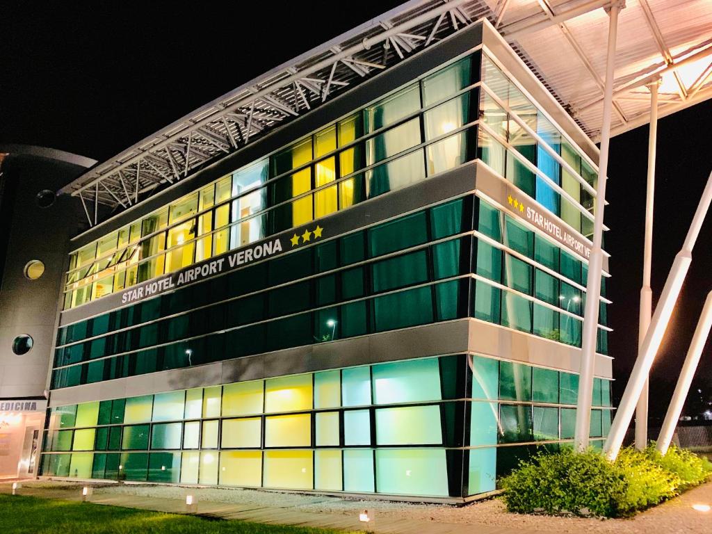 多索博诺维罗纳机场星级酒店的一座大型建筑,晚上有五颜六色的窗户