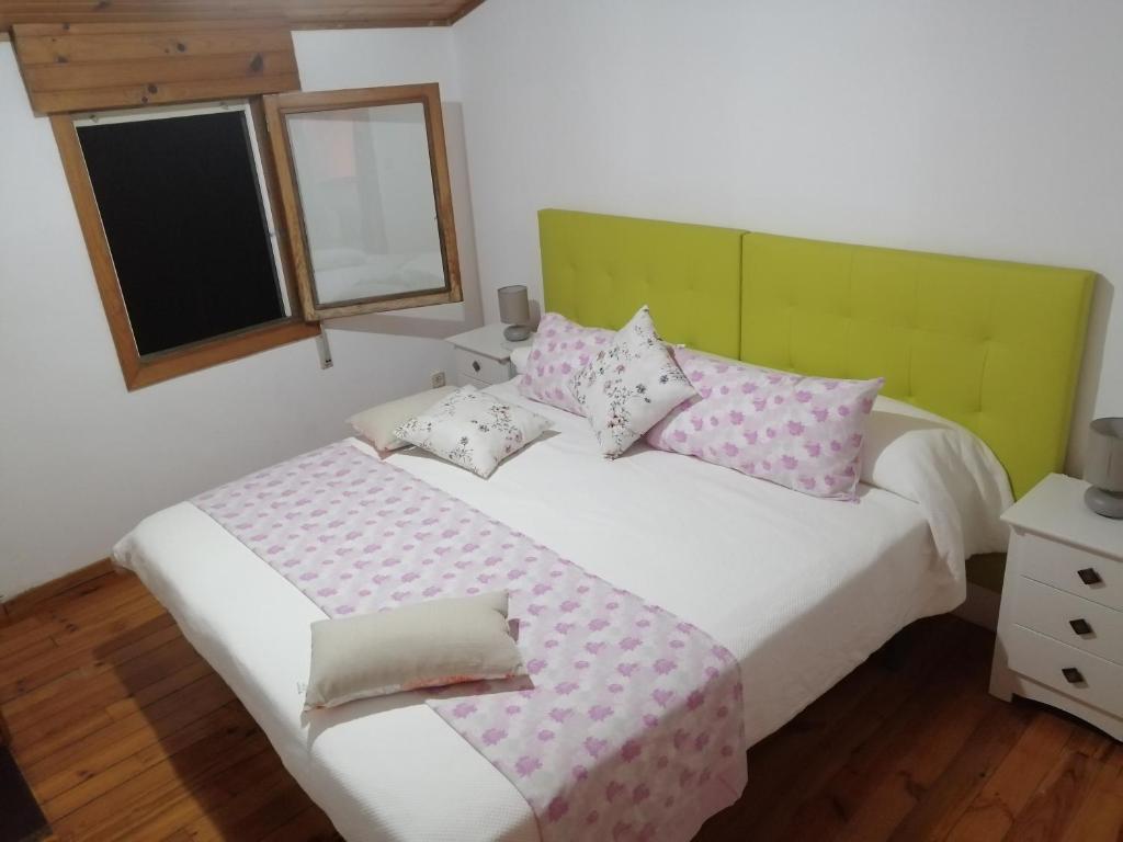 里瓦达维亚O Tipico的一间卧室配有带粉色和白色枕头的床