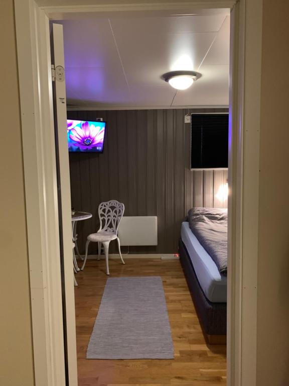 莱克内斯Cozy & private room in the middle of Lofoten的卧室配有一张床,墙上配有电视。