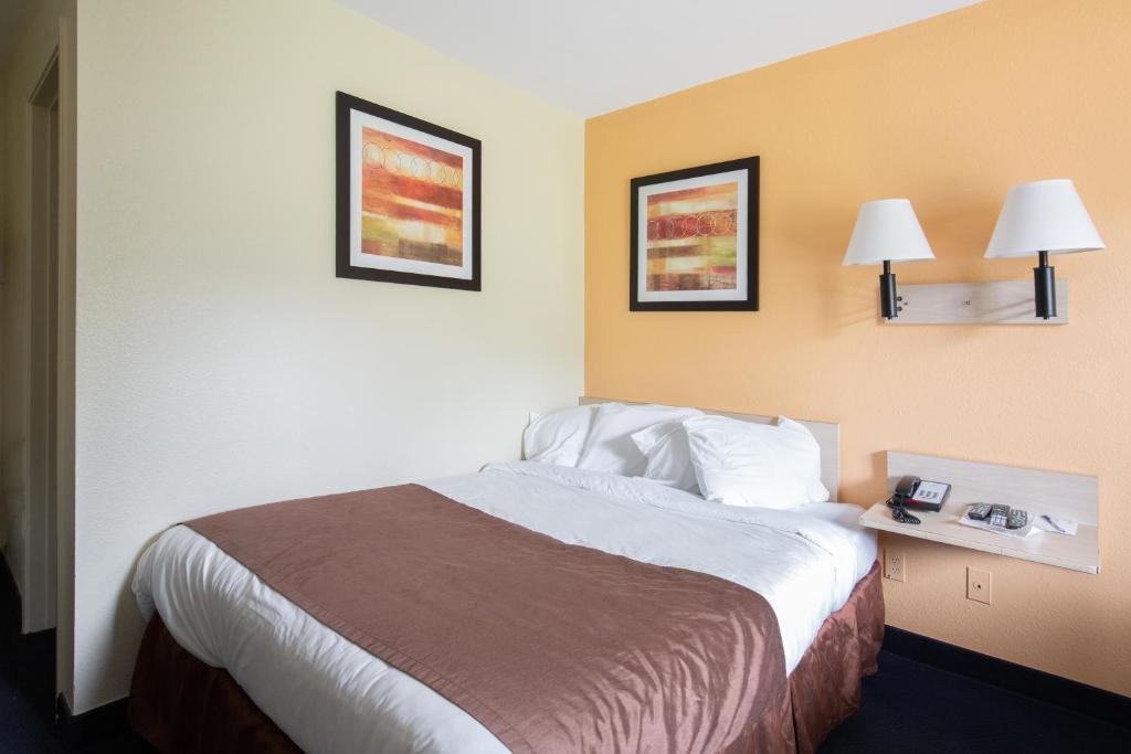 新费城Days Inn by Wyndham New Philadelphia的酒店客房,配有一张床,墙上挂有两张照片