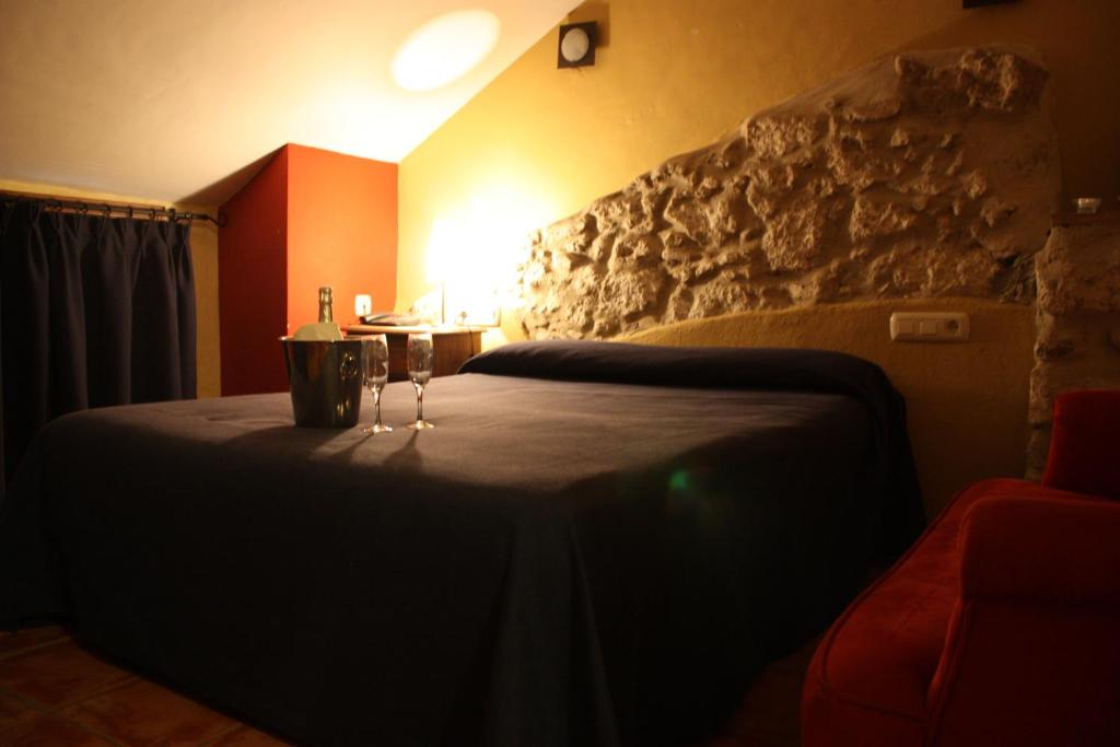 阿洛拉堂佩罗酒店的一间卧室配有一张带两杯酒杯的床