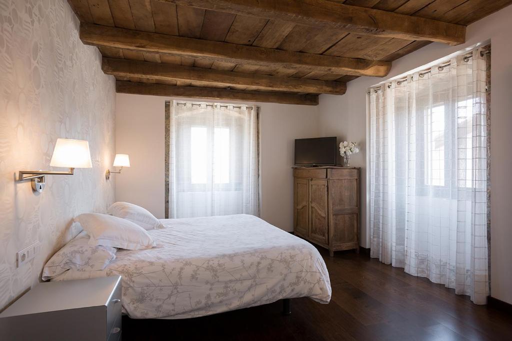 OskotzCasa Rural Enea的一间卧室设有一张大床和两个窗户。