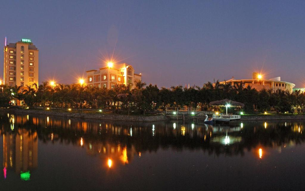 海防卡梅拉度假酒店的一座有建筑的城市,晚上有河流