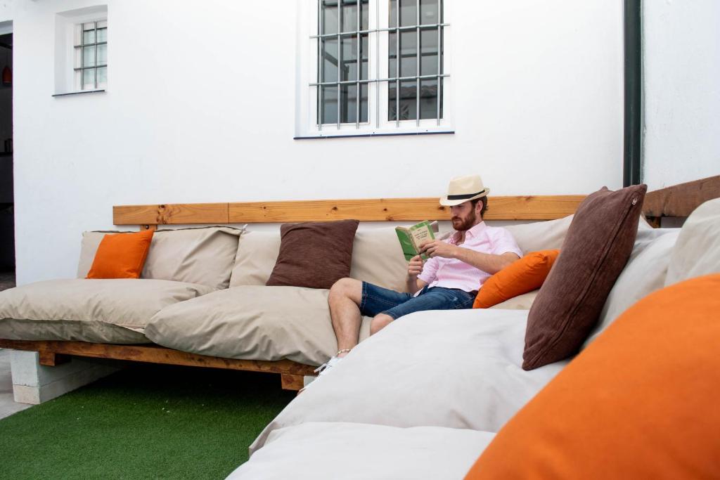 马拉加Casa Juan Breva的坐在沙发上读书的人