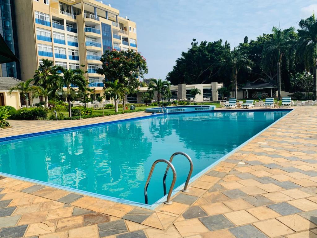 坦噶Tanga Beach Resort & Spa的一座位于酒店后面的度假胜地的游泳池