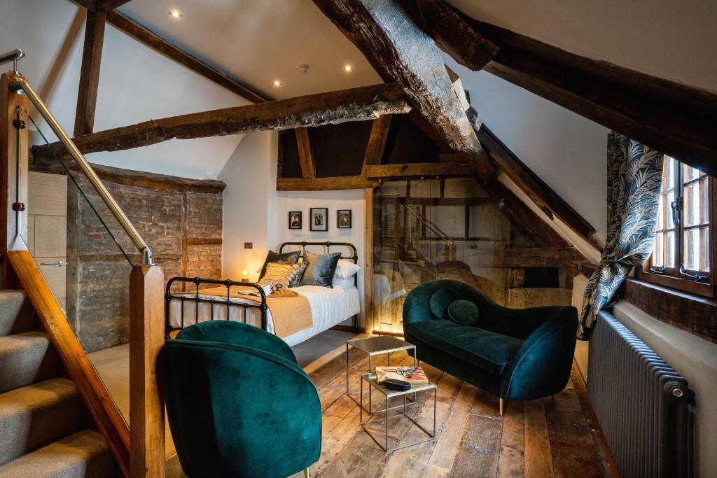 伍斯特Old Infirmary的一间卧室配有一张床和两张绿色椅子