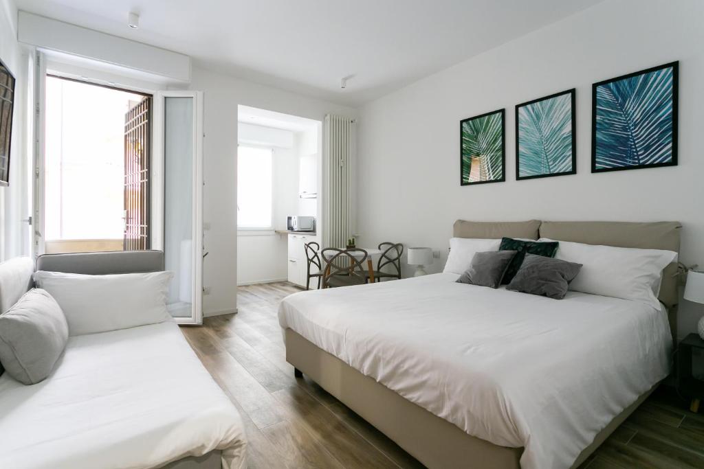 米兰Milanofierapartments的卧室设有2张床和白色的墙壁。