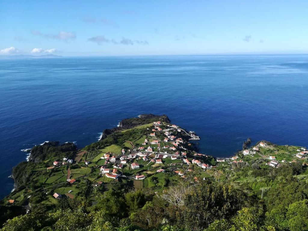 Fajã do OuvidorCasa da Eira Velha的海洋上的岛屿,上面有房子