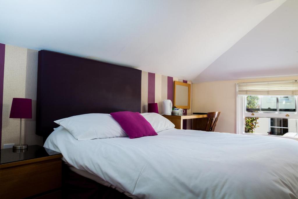 朴次茅斯白金汉公爵酒店的卧室设有一张白色大床和一扇窗户。