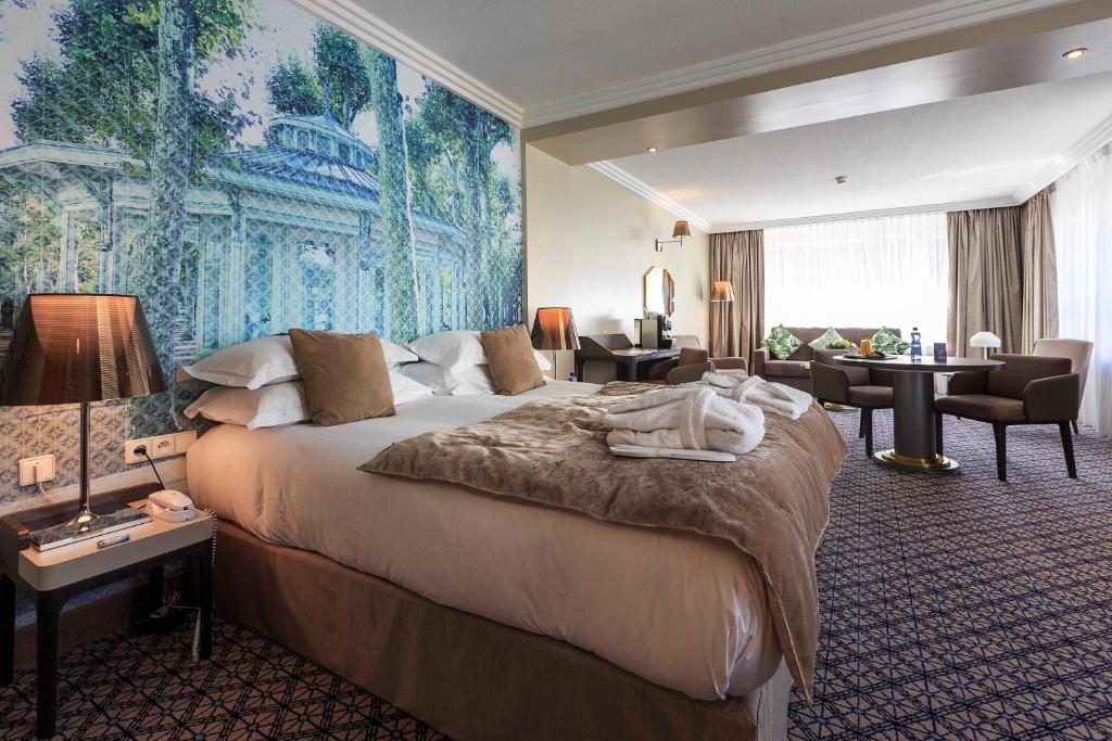 维希Vichy Célestins Spa Hôtel的酒店客房设有一张床,墙上挂着一幅大画