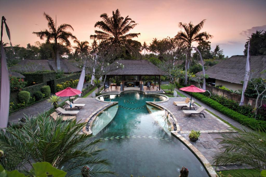 乌布FuramaXclusive Resort & Villas, Ubud的享有带椅子和凉亭的度假游泳池的空中景致