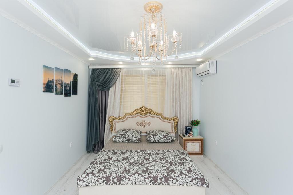 苏梅De LUXE apartments Centr 1 floor的一间卧室配有一张大床和一个吊灯。