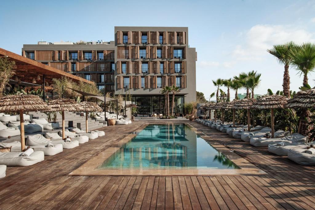 圣安东尼奥OKU Ibiza的一个带游泳池和棕榈树的度假村