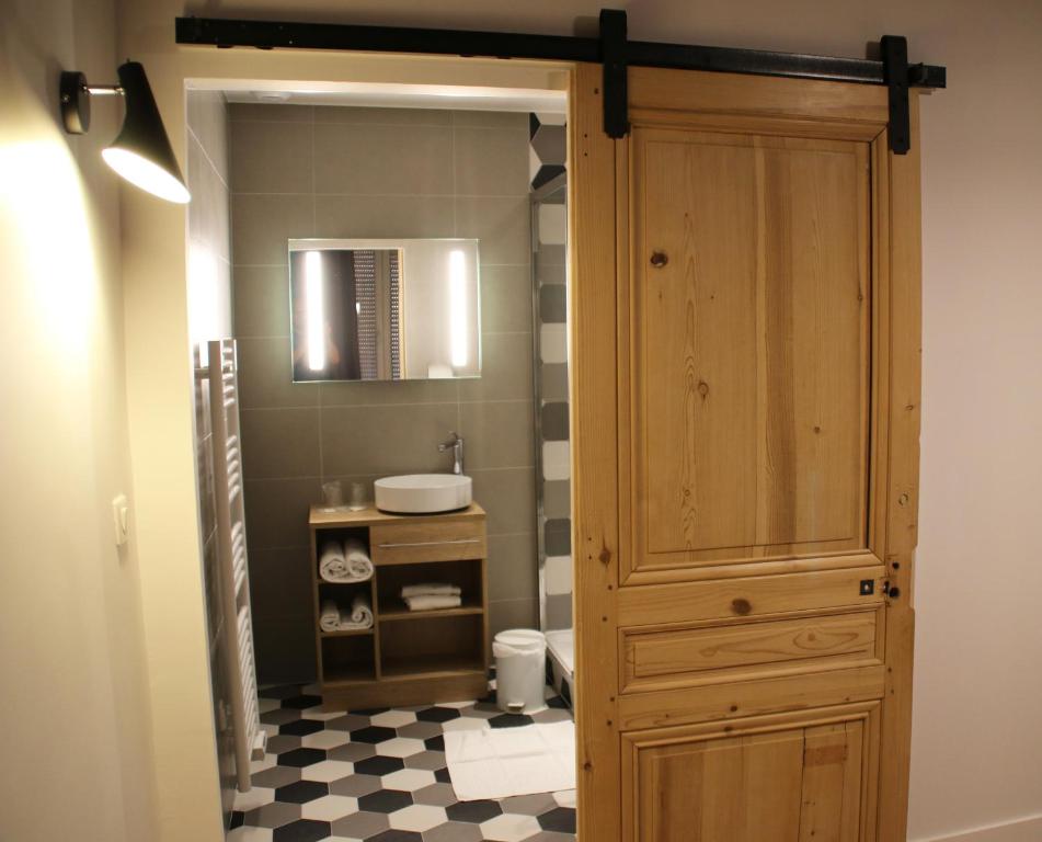 里昂圣文森特酒店的一间带木制橱柜和水槽的浴室