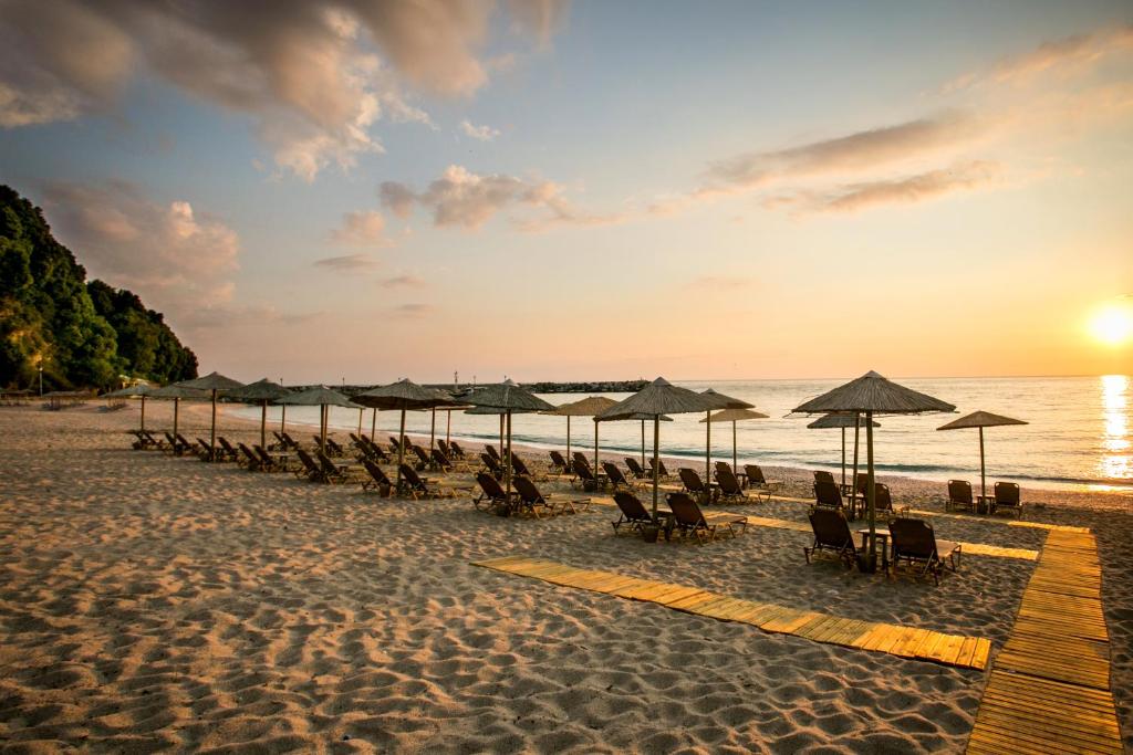 阿吉奥斯伊欧尼斯Kenta Beach Hotel的海滩上的一组椅子和遮阳伞