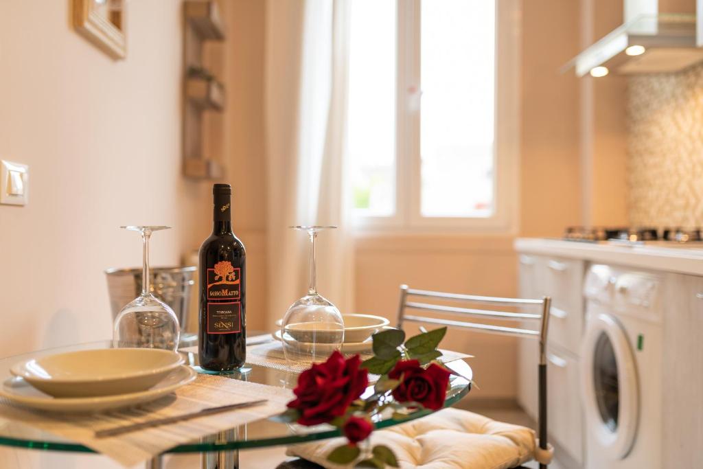 佛罗伦萨Dante Experience Apartment的厨房里的桌子上摆放着一瓶葡萄酒
