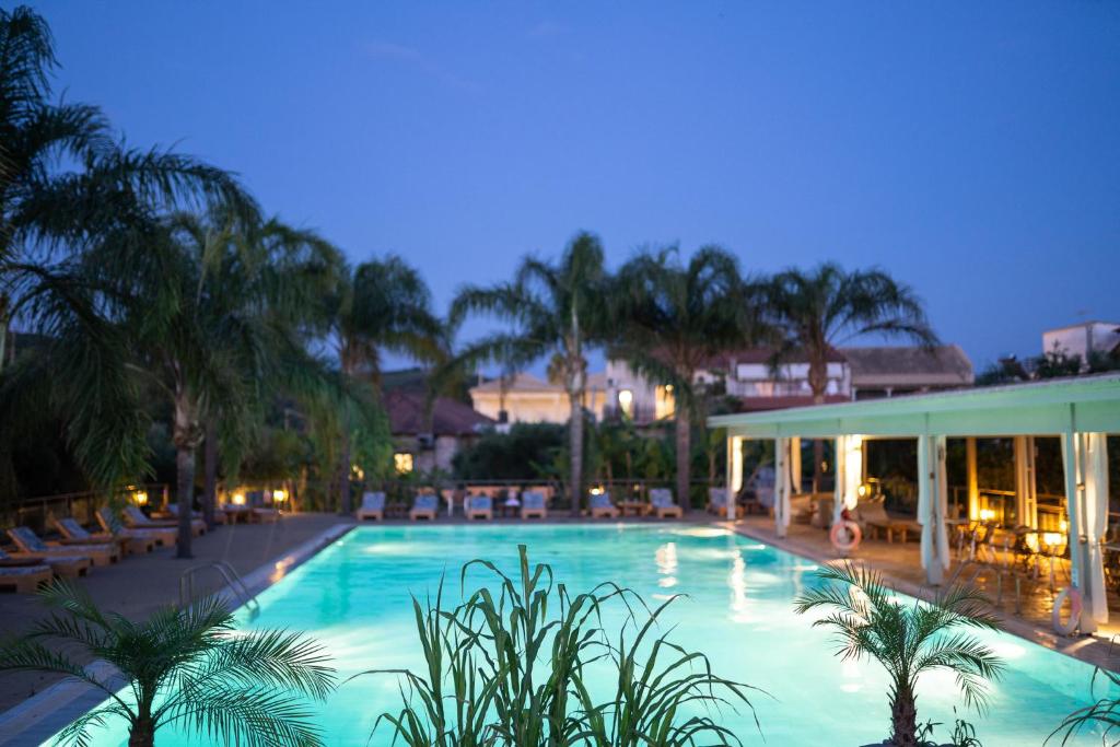吉亚洛瓦Zoe Seaside Resort的一个带椅子和棕榈树的大型游泳池